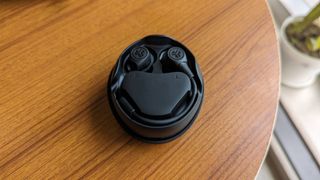 JLab Work Buds wireless earbuds with detachable microphone kept on a table.