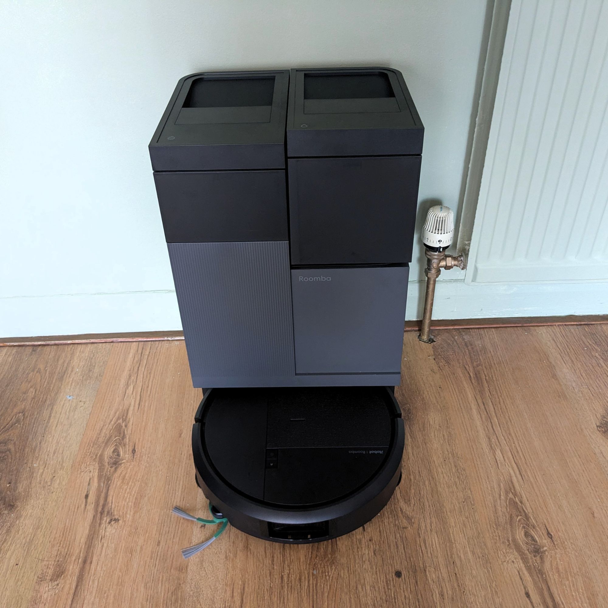 iRobot Roomba Plus 415 Combo sitting on dock on wooden floor