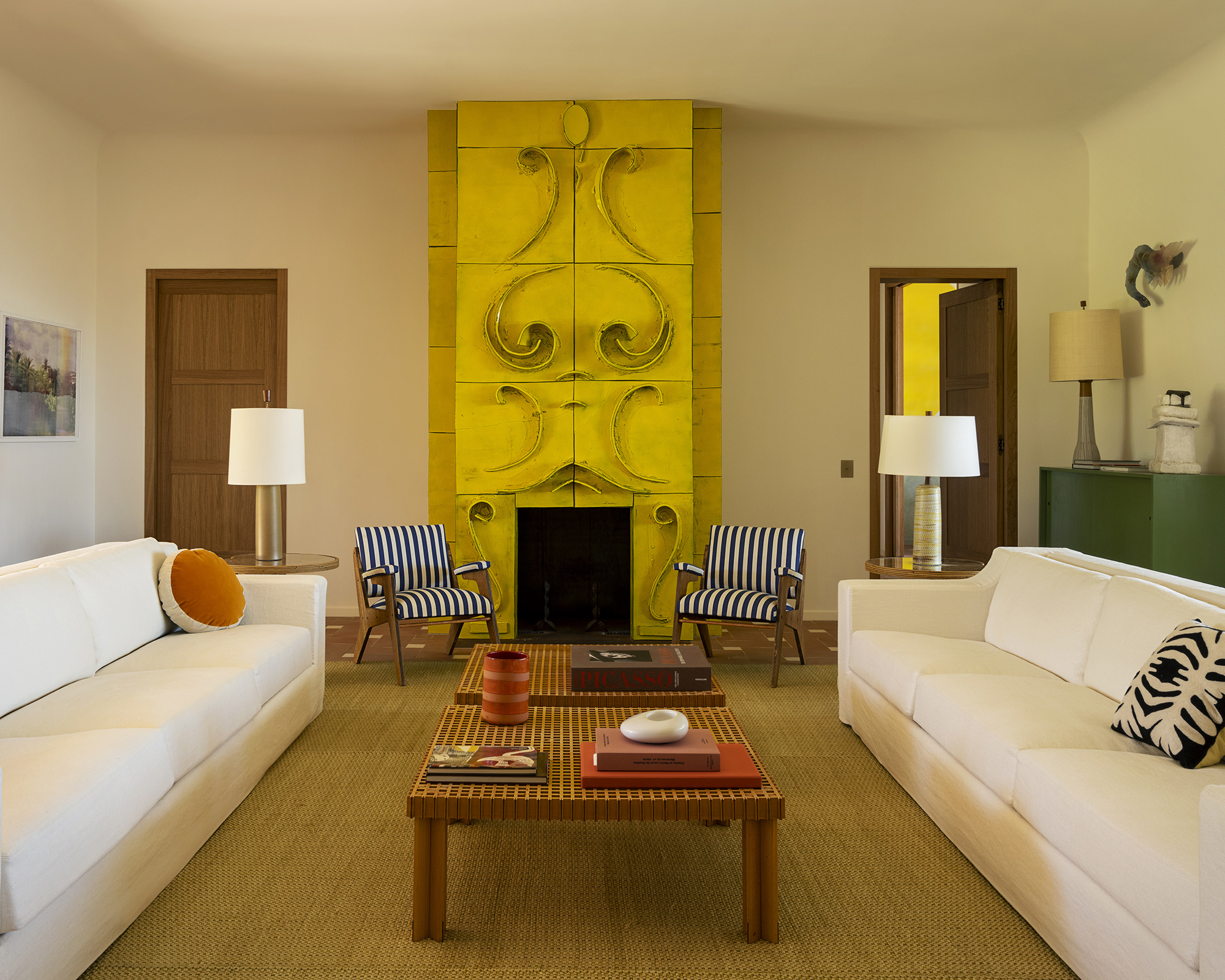 living room with two white sofas facing each other and a large yellow artwork on the wall
