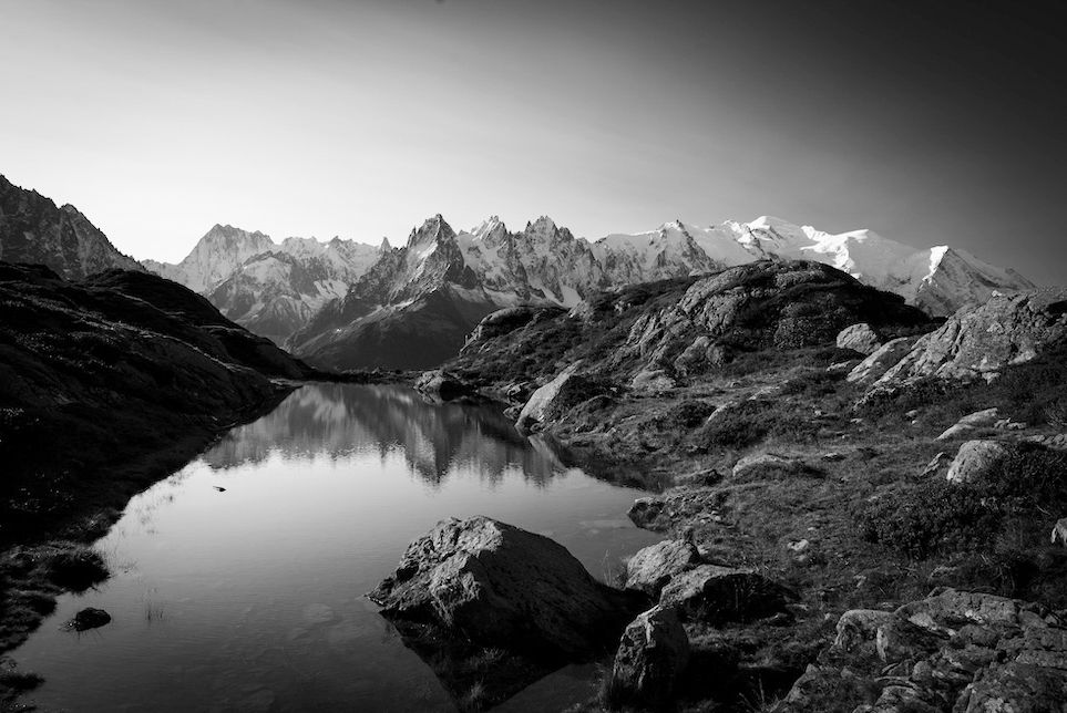 A black-and-white landscape with light settling on Mont Blanc in the background 