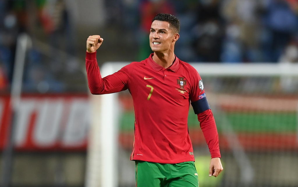 Portugal's national soccer team player Cristiano Ronaldo signs a team jersey  for an airport worker after getting off the airplane in Geneva,  Switzerland, Sunday, June 1 2008, as the team arrives for