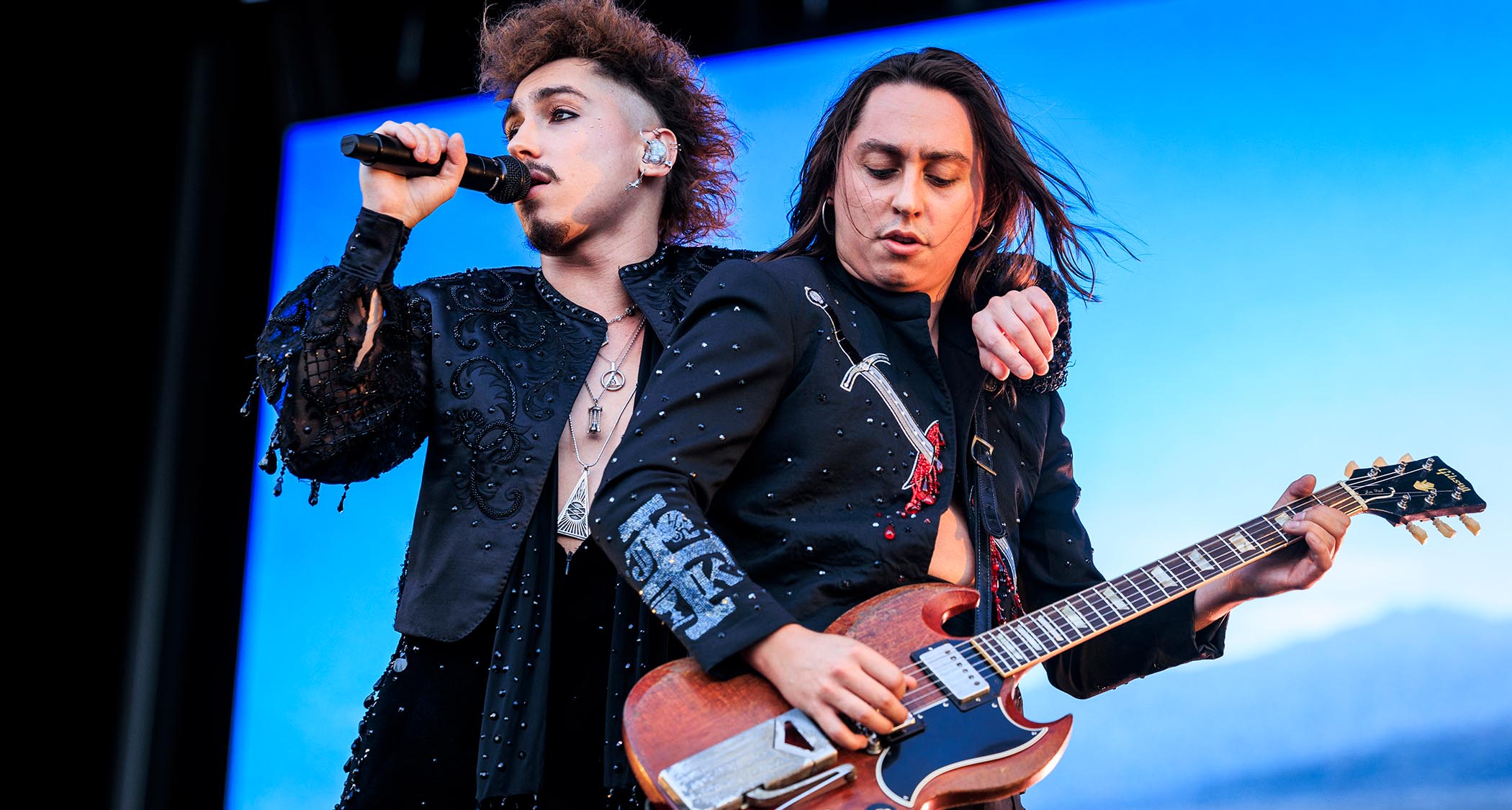 Greta Van Fleet's Joshua Kiszka (left) and Jake Kiszka perform at Pinkpop 2024, with the singer's arms around his brother who is playing a Gibson SG.