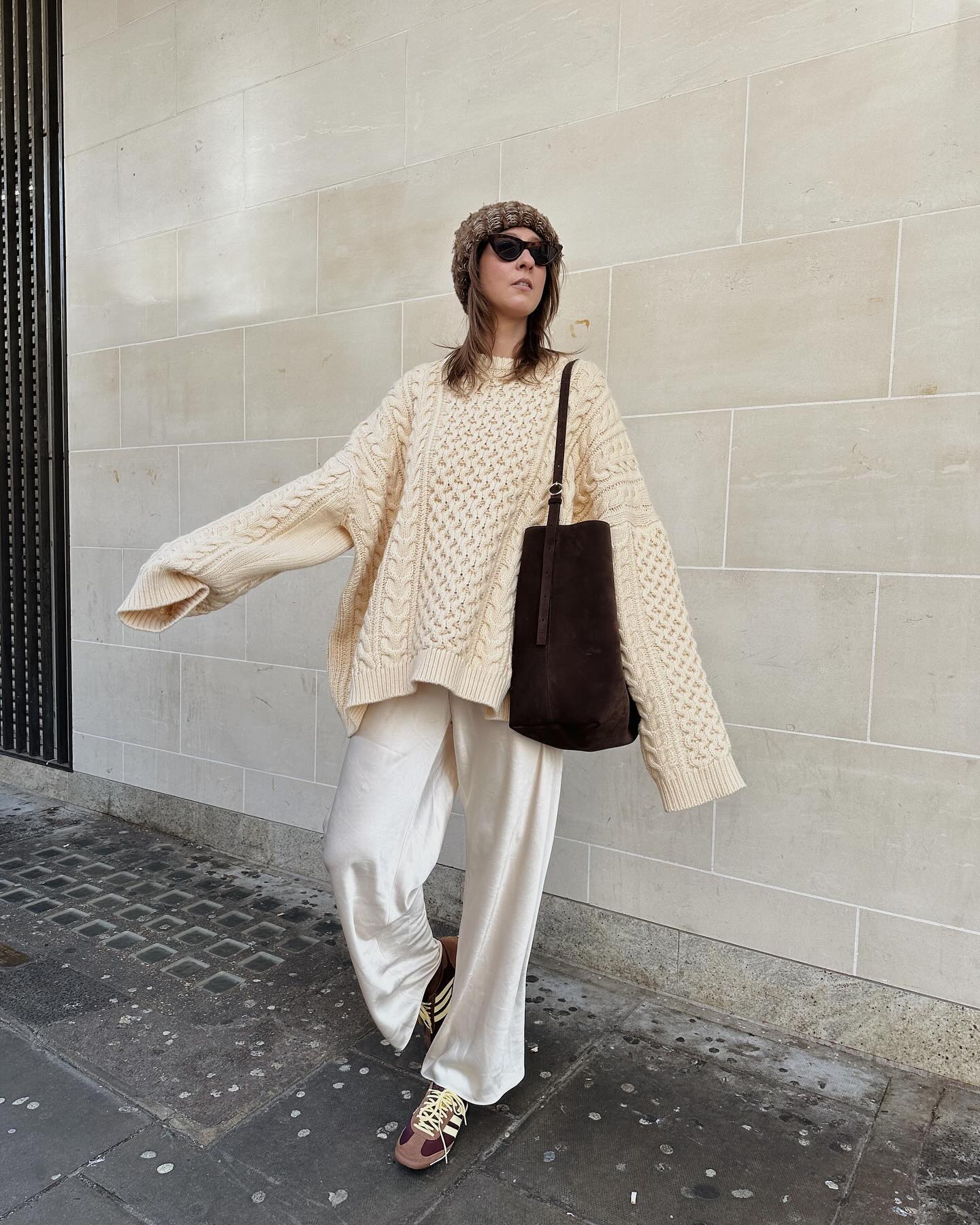 Spring trainer outfits: @bubblyaquarius wears a cable-knit jumper with wide trousers and trainers