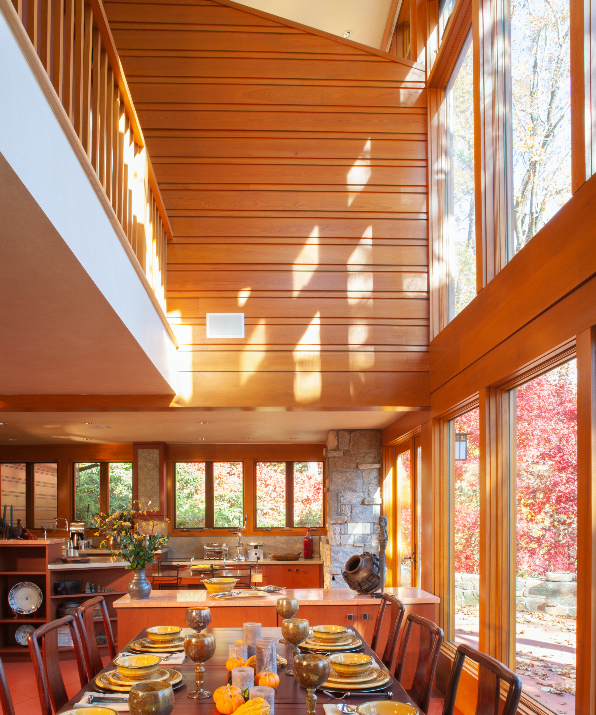 inside of a Frank Lloyd Wright home with wooden clad interior and a lower ceiling opening up to a large vaulted space