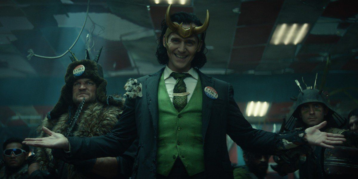 Loki (Tom Hiddleston) smiles and stands among his &quot;allies&quot; on Loki (2021)