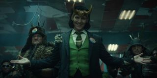 Loki (Tom Hiddleston) smiles and stands among his "allies" on Loki (2021)