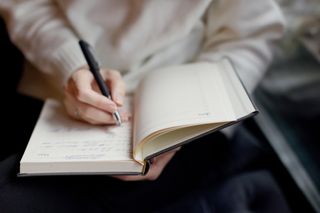 A person writing in a notebook.