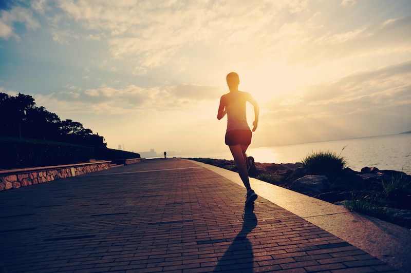 A woman goes running at sunrise