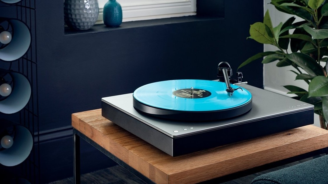 A photo of the Cambridge Audio Alva TT record player on a wooden table in a sitting room setting