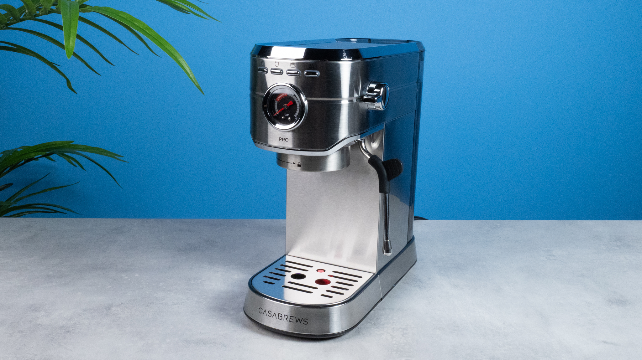 The Casabrews 5418Pro espresso machine in stainless steel with a steam wand on the right side and three buttons on the front of the machine and a pressure gauge underneath