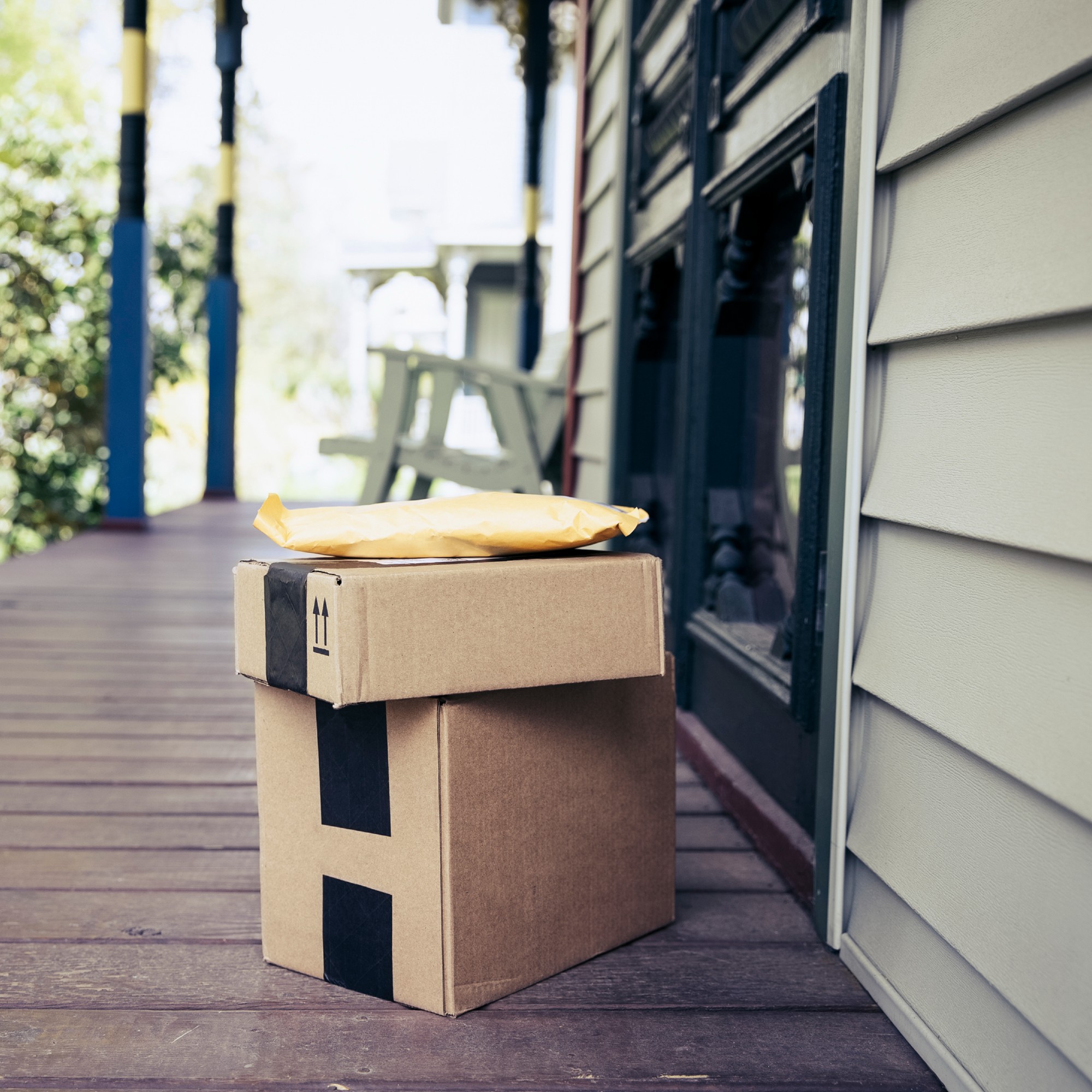 A stack of parcels in cardboard packaging on a front porch