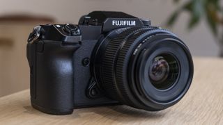 The Fujifilm GFX50S II camera on a wooden table