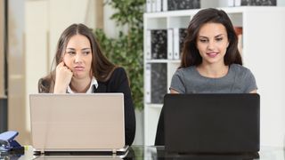 two women using laptops