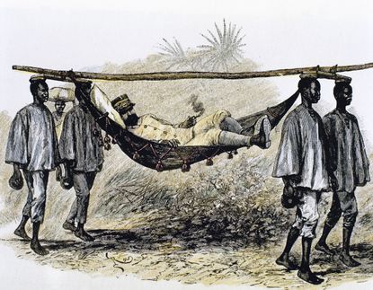 European colonizer carried in a hammock by four African porters.