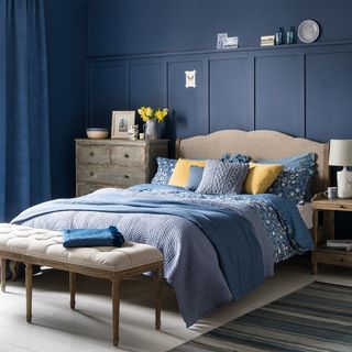 bedroom with blue wall bed and white cushion