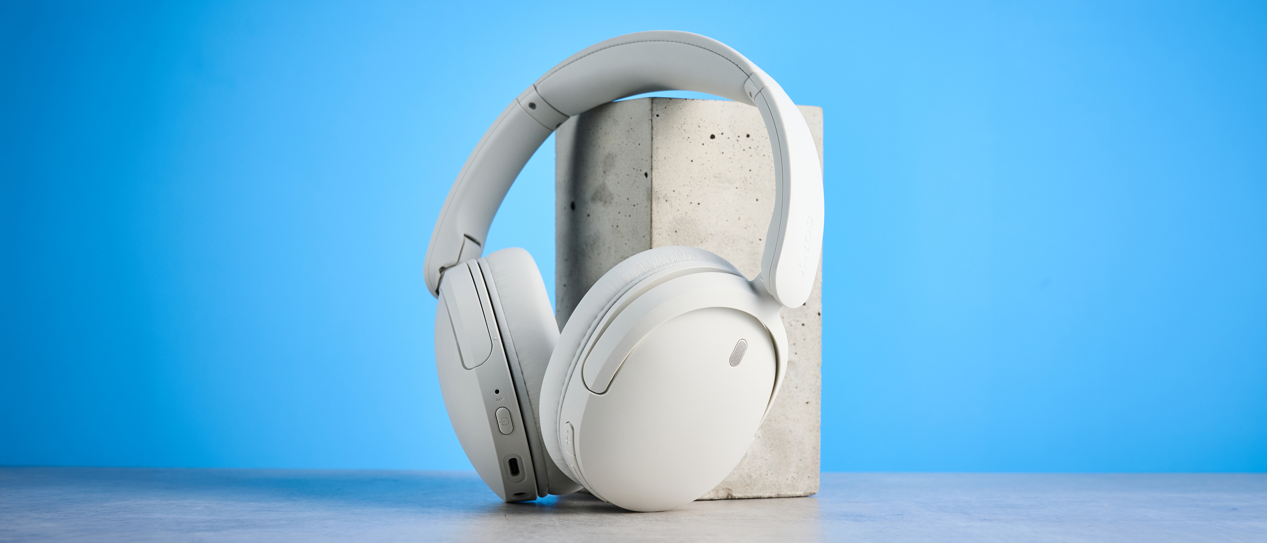 Sony WH-CH730N in white photographed in front of a blue background