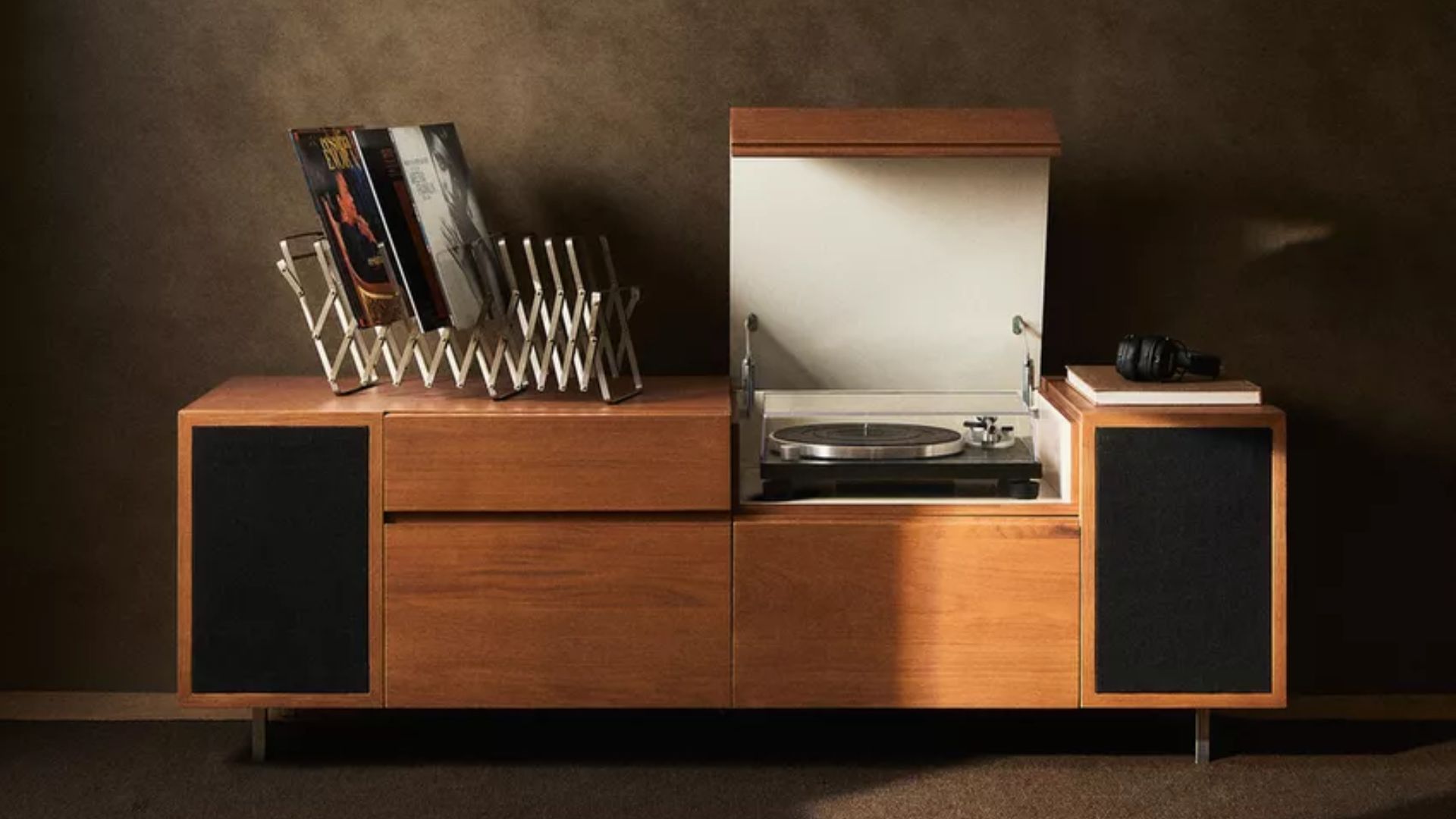 A wood record bar with an extendable magazine rack on top and an open compartment for a turntable