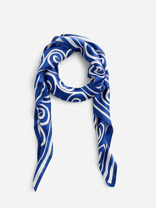 a blue and white silk scarf by madewell in front of a plain backdrop in a guide to hailey biebers scarf top
