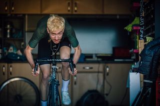 Male cyclist completing a V02 Max interval cycling workout indoors