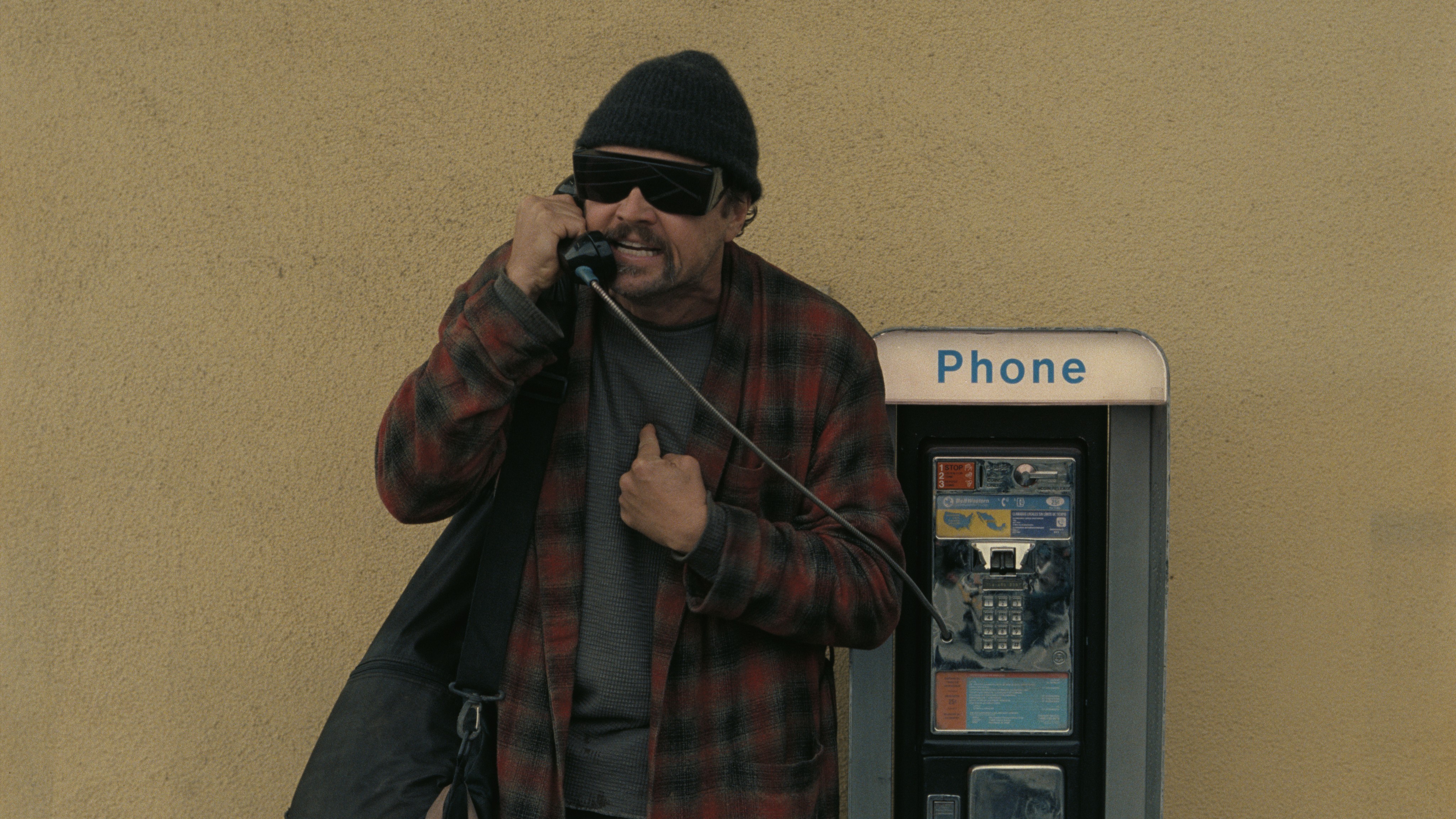 Leonardo DiCaprio uses a payphone in a scene from &quot;One Battle After Another&quot;
