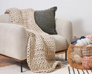 Beige knit blanket on gray chair