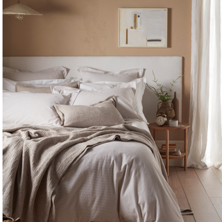 A double bed made with sheets and pillows