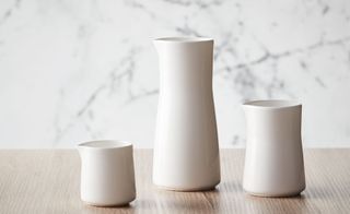 Three white bone china vessels of different sizes