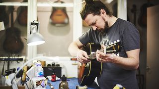 Man checking setup on acoustic guitar