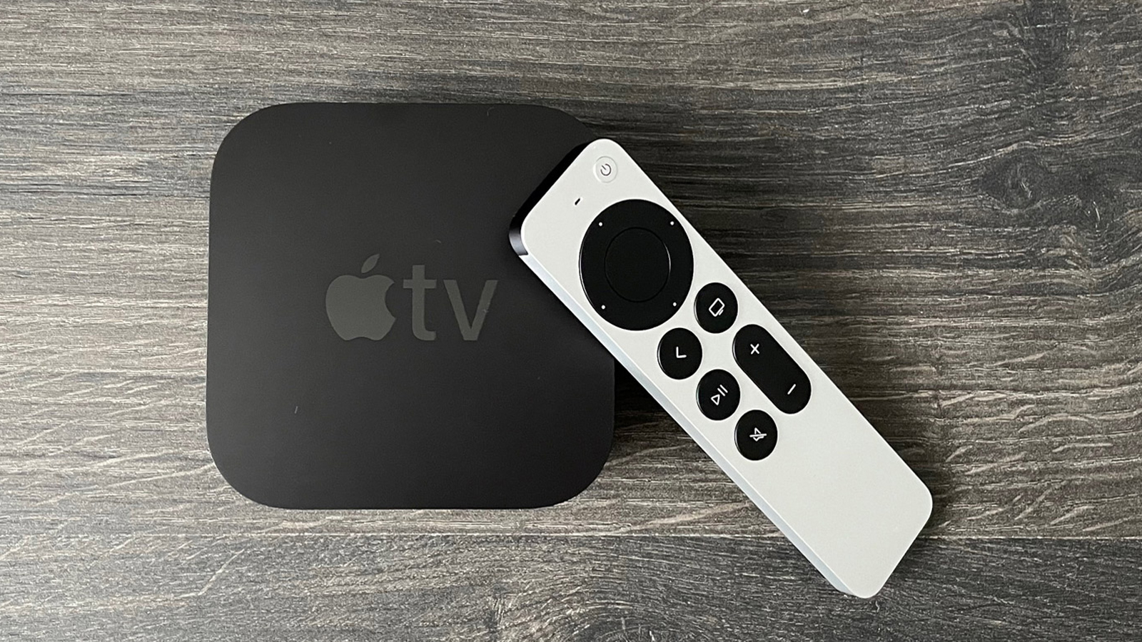  Apple TV 4K 2021 года и его пульт дистанционного управления лежат на столе