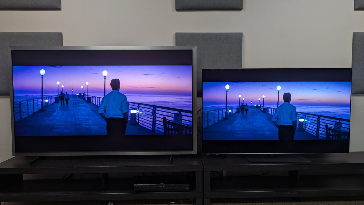 Samsung S99H (left) vs LG G6 (right) showing Sebastian walking on a pier at sunset from La La Land. Both TVs accurately render the gradient of the sunset