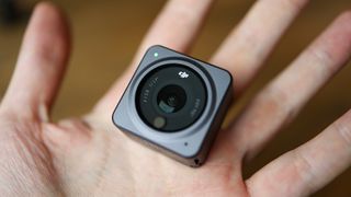 A hand holding the DJI Action 2 action camera