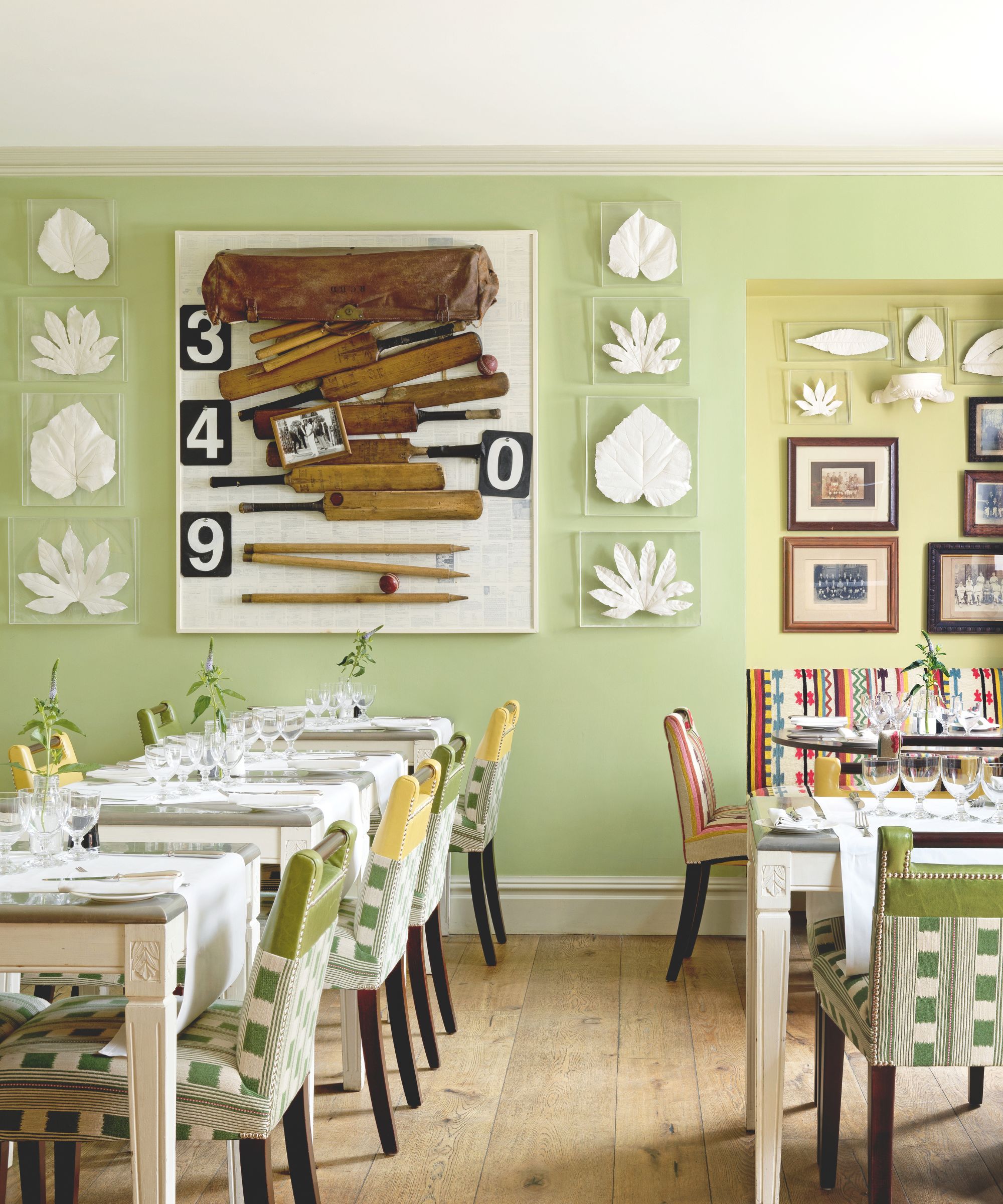 Restaurant with pale green walls and cricket artwork on the walls