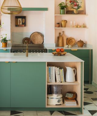 modern kitchen with blue/green cabinets and peachy walls with open shelves and gold pendant light