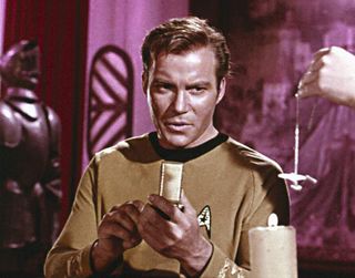 Screenshot from an episode of Star Trek showing Captain Kirk using a hand-held communications device.
