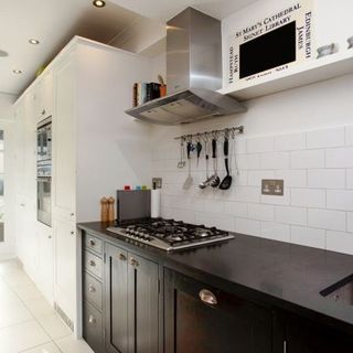 white kitchen with black worktop and cooker