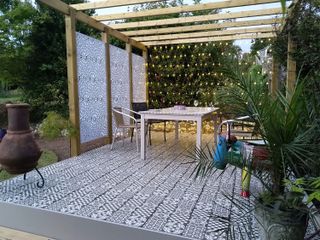 garden screening ideas: decorative screened sides of pergola over seating area