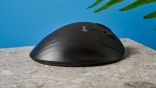 A black Logitech Ergo M575 ergonomic mouse with a teal trackball on the left side