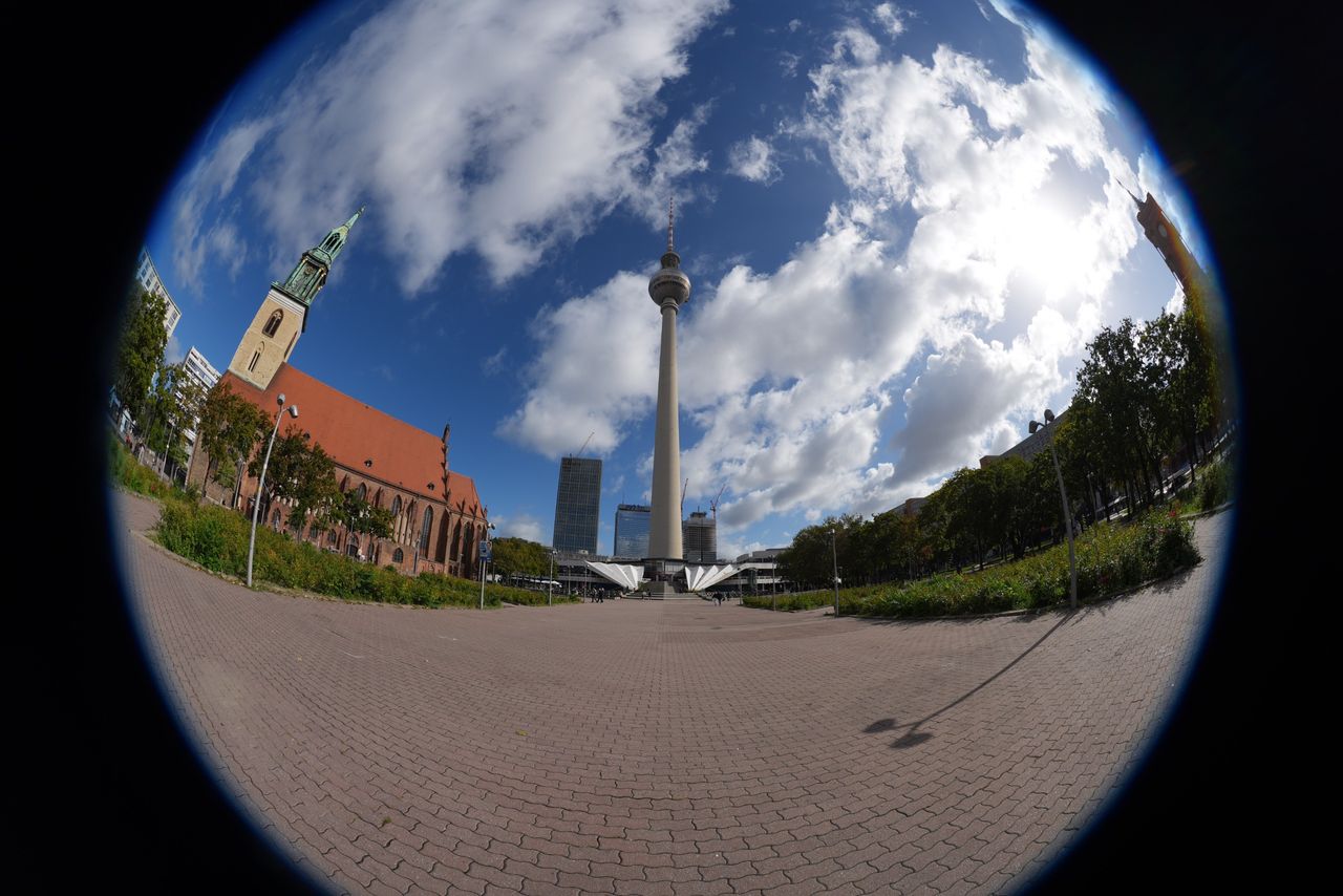 Circular fisheye view of Berlin&rsquo;s Fernsehturm TV tower and St. Mary&rsquo;s Church, surrounded by a black frame.