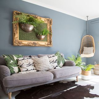 living room with grey wall potted plants and sofa set with cushion