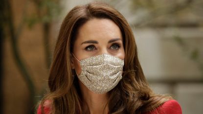 Wearing a face covering to curb the spread of coronavirus, Catherine, Duchess of Cambridge meets pharmacist Joyce Duah as she and Prince William visit St. Bartholomew's Hospital in London, to mark the launch of the nationwide 'Hold Still' community photography project