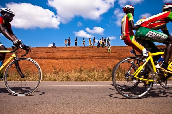 Young fans watch the breakaway pass through a road cut in the hills of southwestern Burkina Faso.