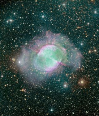 The Dumbbell Nebula shines with spectacular colors in this amazing image captured by the Canada-France-Hawaii Telescope atop Mauna Kea in Hawaii.
