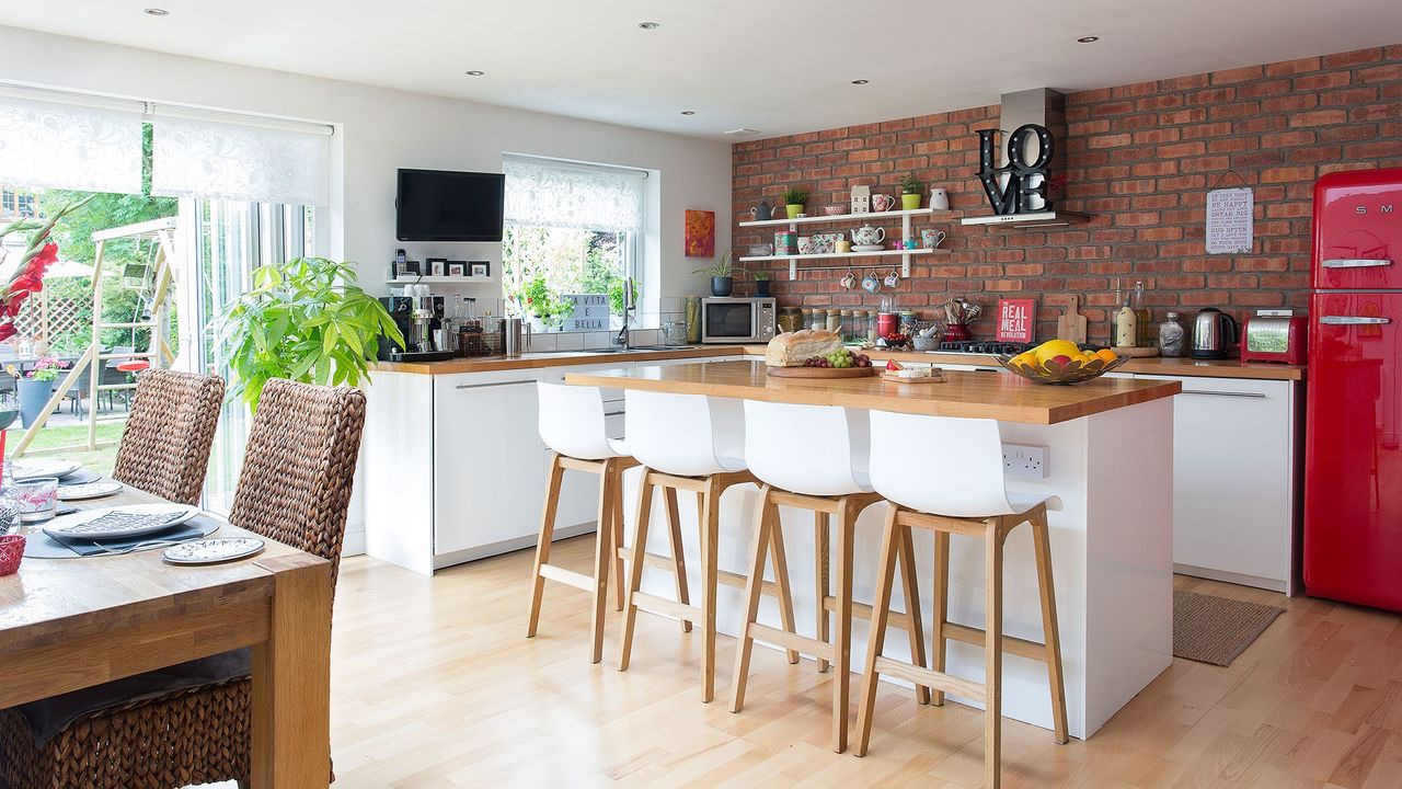 kitchen with brick wall white cabinet and wooden worktop