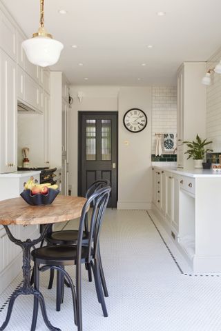 A galley kitchen with a small breakfast table