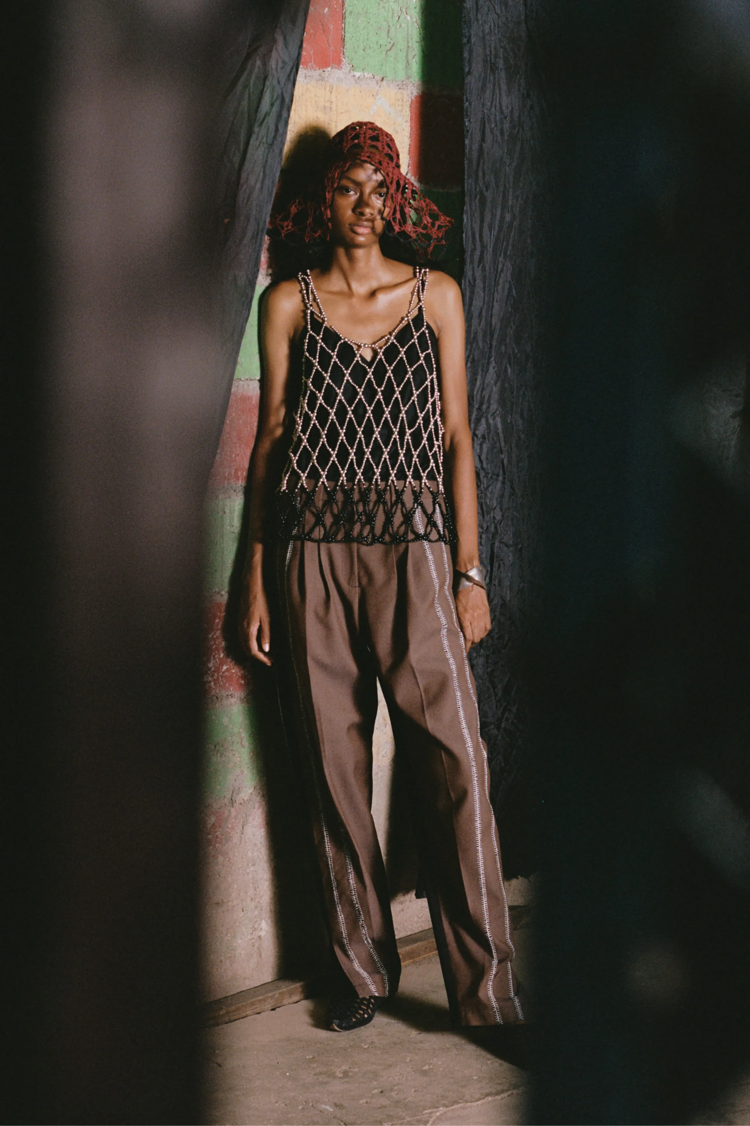 Model wearing a crochet tank top and track pants by Diotima