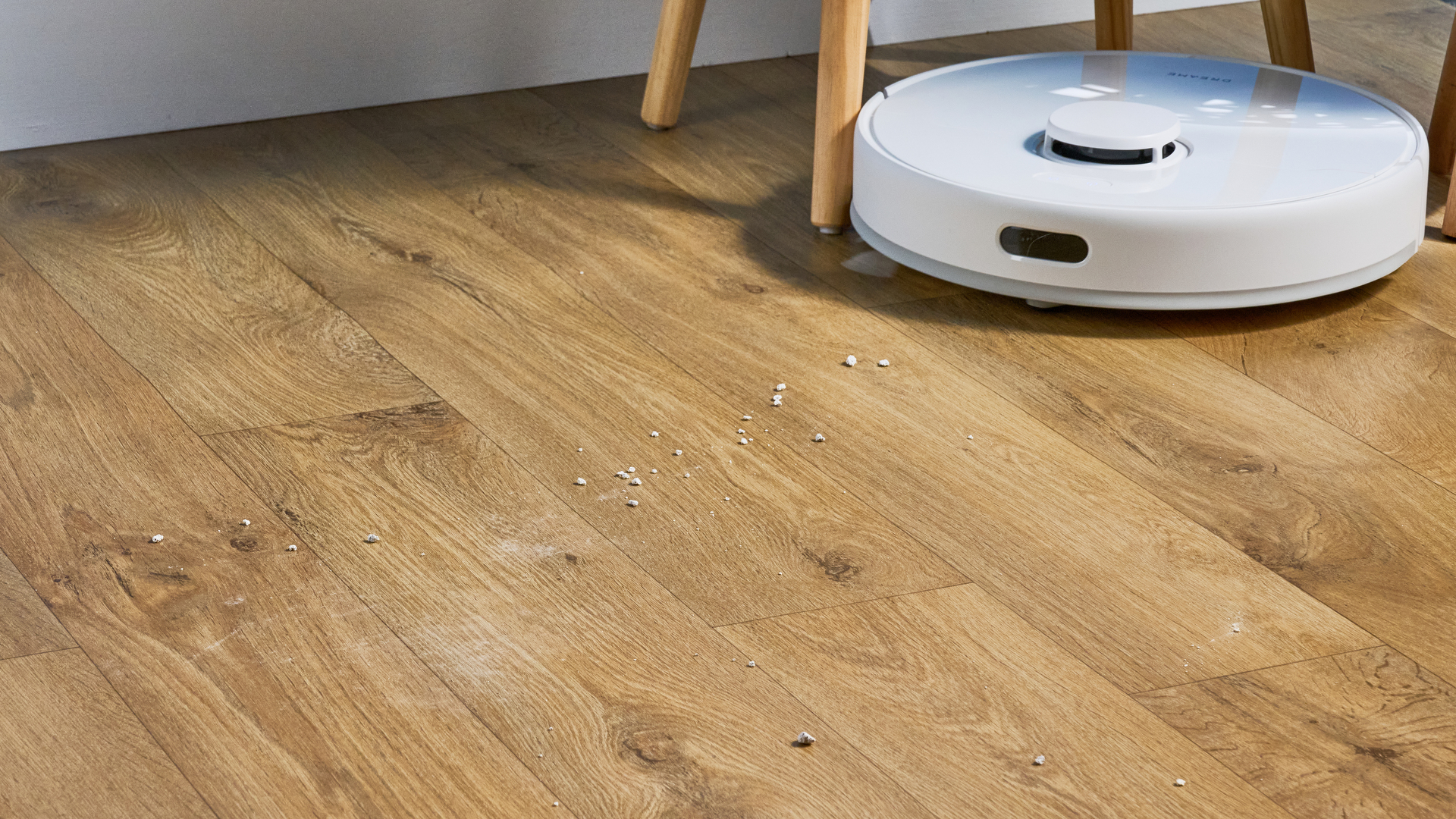Dreame D10 Plus Gen 2 photographed on a wooden floor in front of a blue backdrop