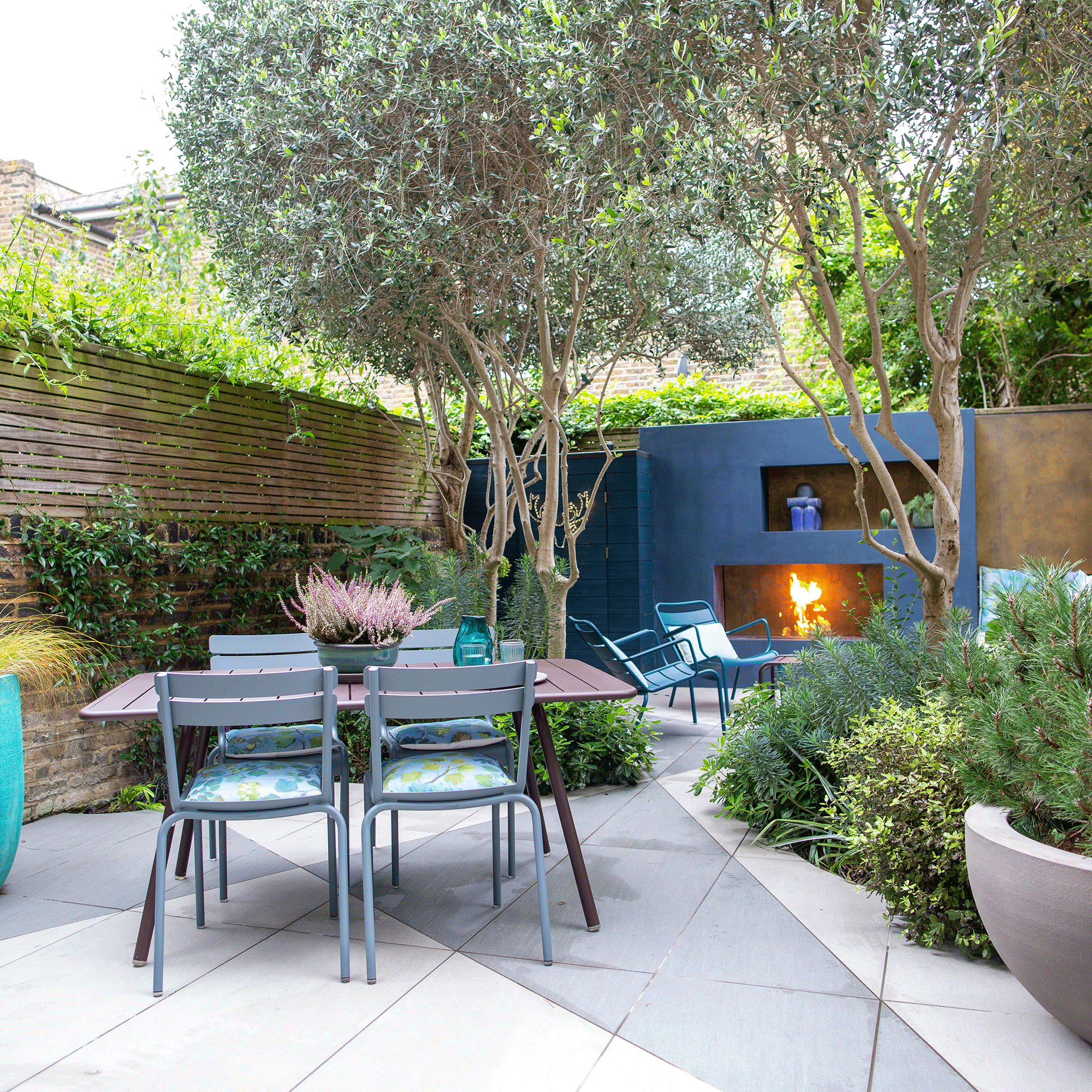 Blue outdoor fireplace with grey patio