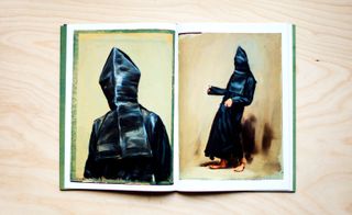 Inside the catalogue shows us two paintings of figures dressed in black robes and a black hood drawn over their head so that we can't see their faces. One figure is standing still, and the other is dancing in a ritualistic way.