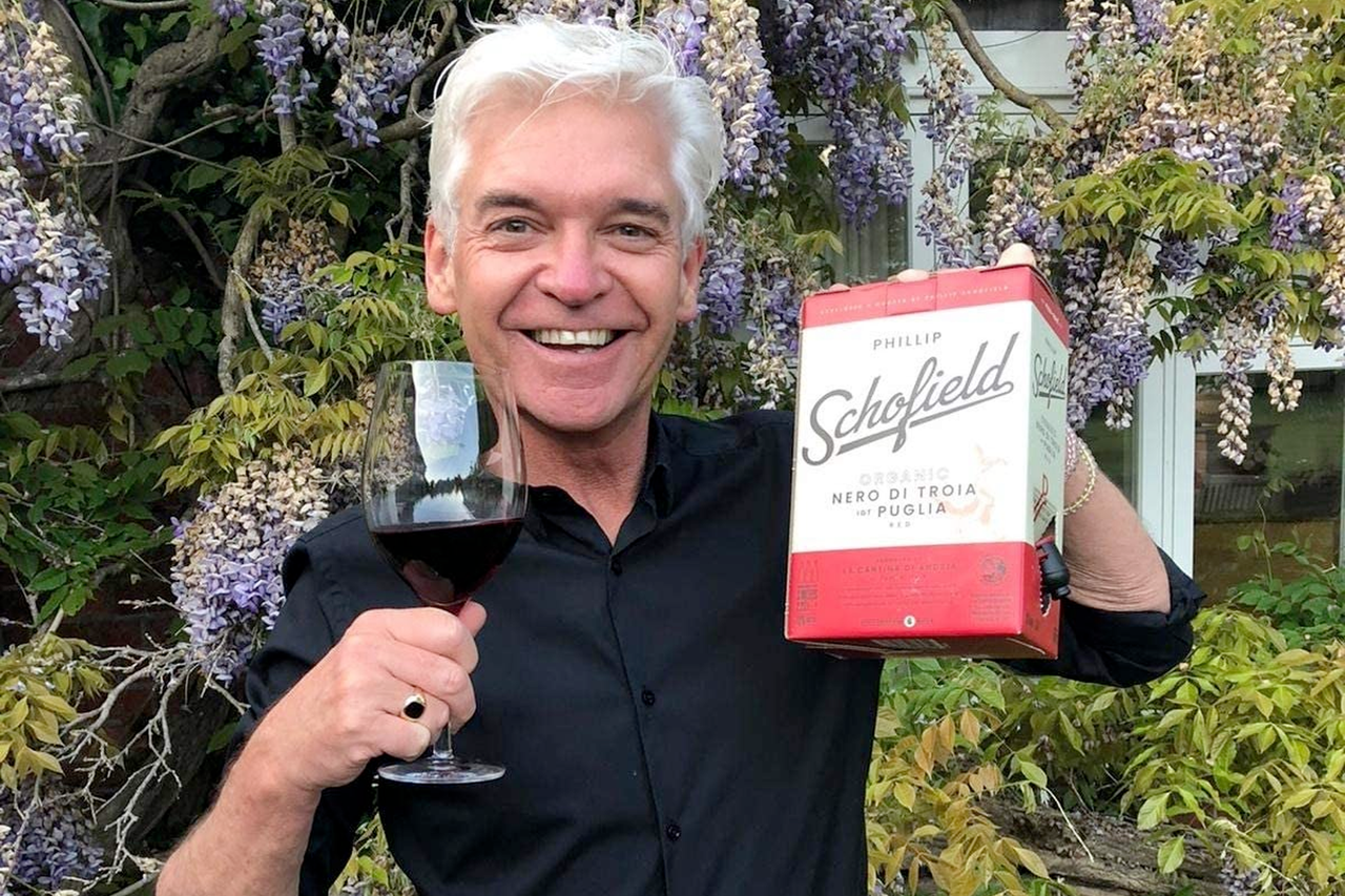 Phillip Schofield holding up his box of Nero di Troia red wine