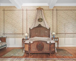 French bedroom with wallpaper panels, antique bed with canopy, wooden floor, vintage rugs, chaise tongue, side tables
